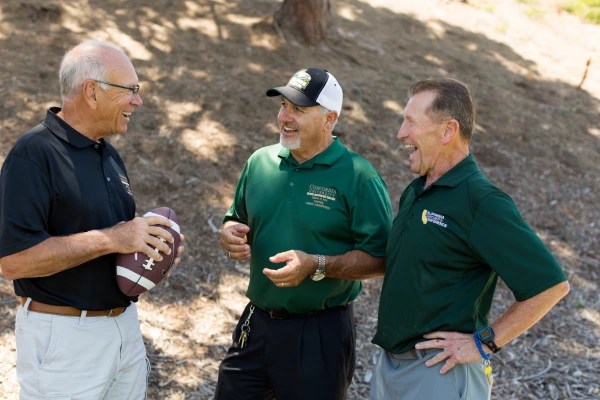 A group of men laughing with a football