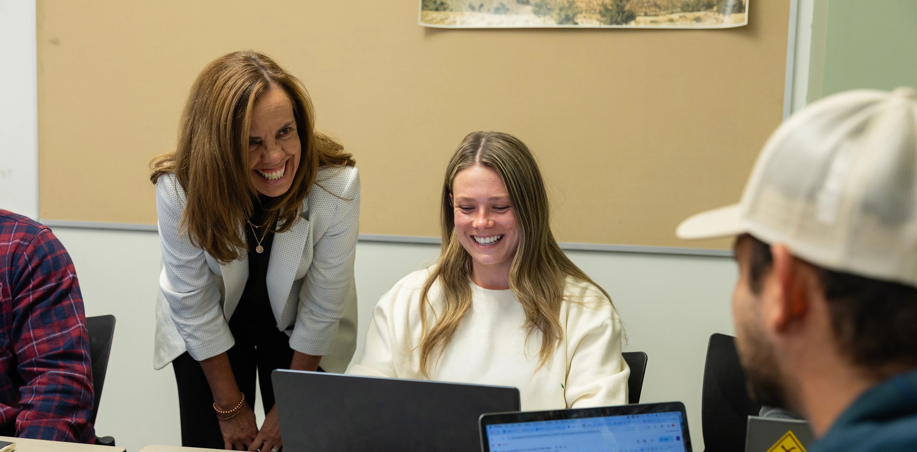 A group of women smiling at a laptop
