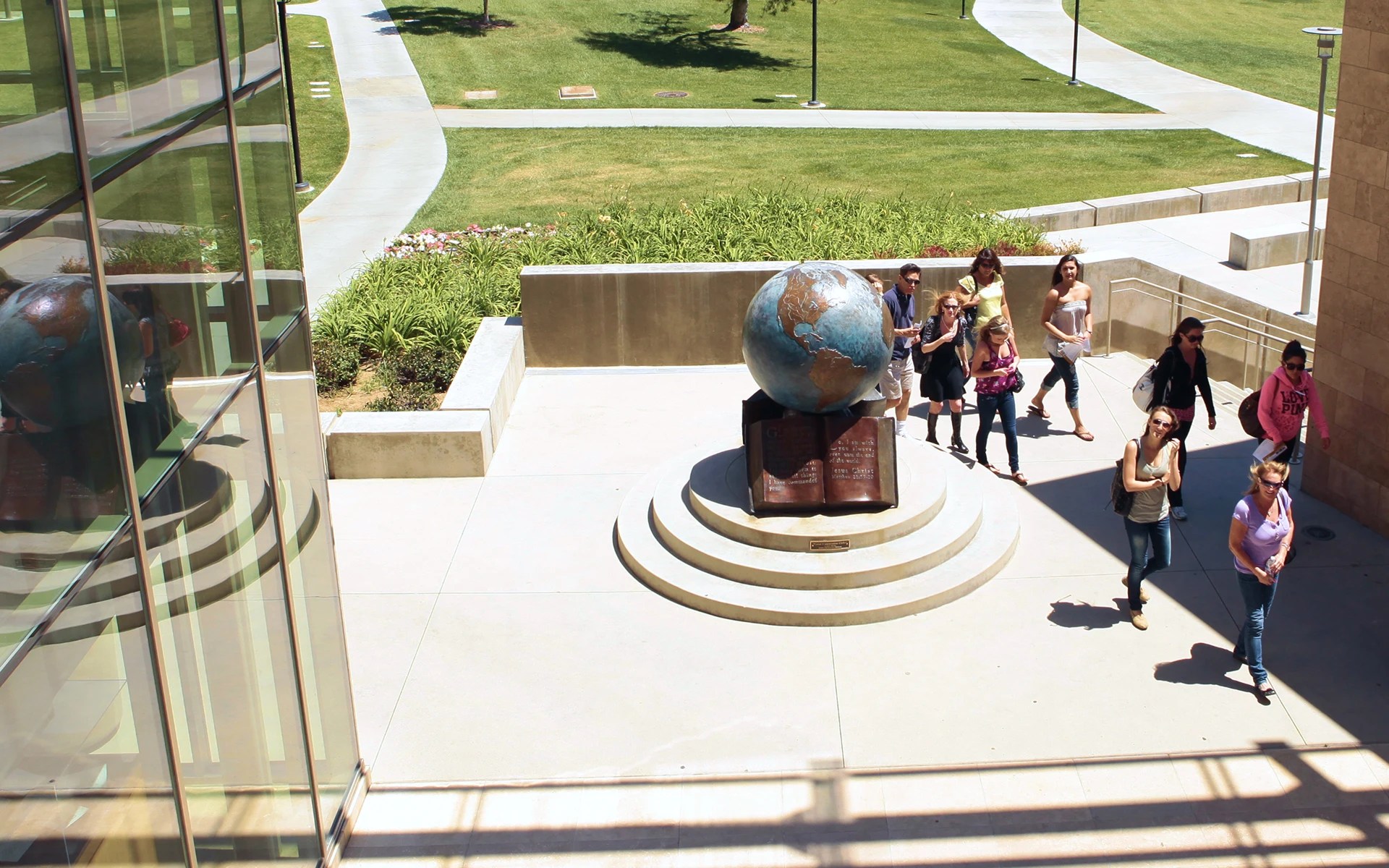 A group of people standing around a globe statue