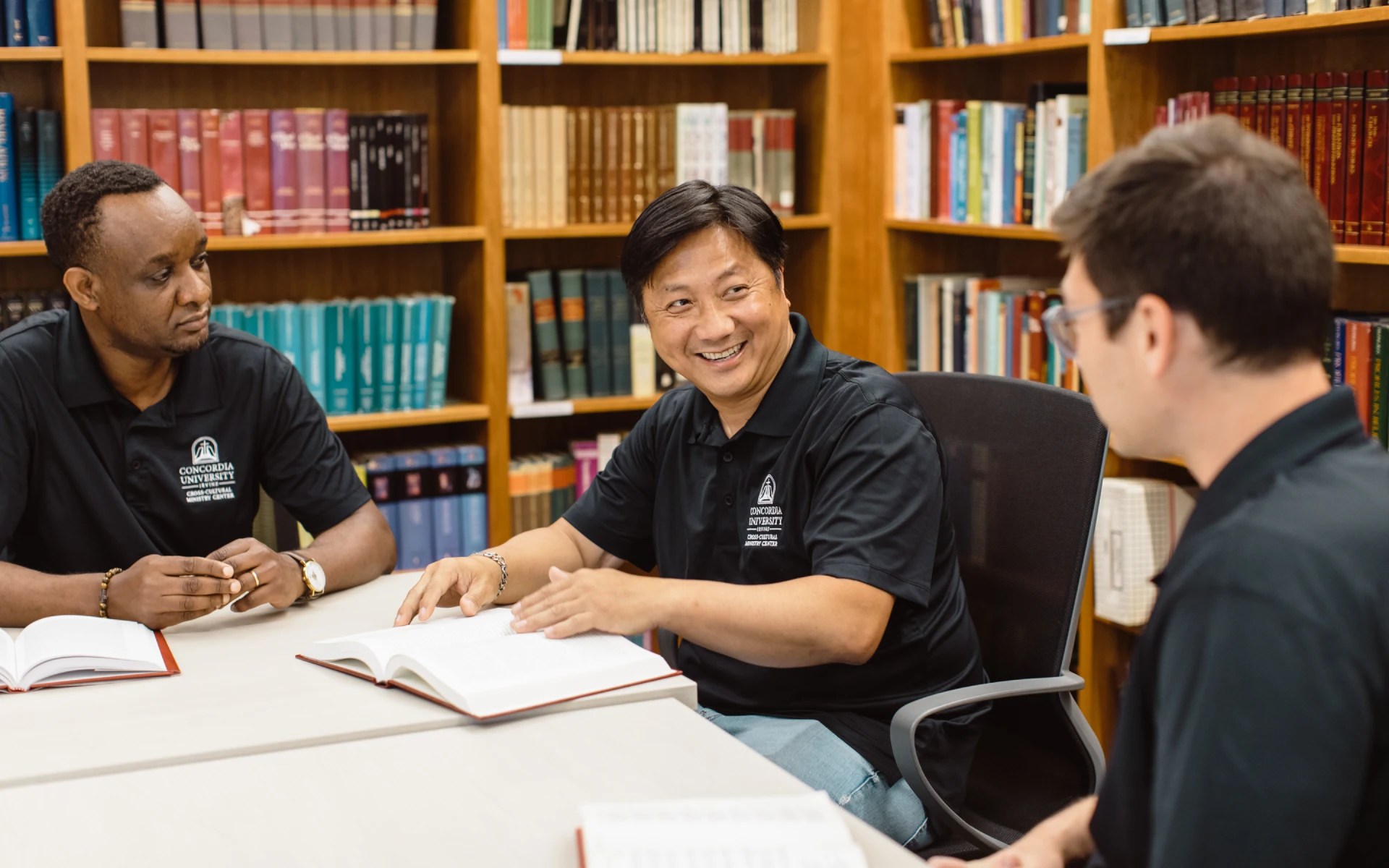 A group of people sitting at a table with books