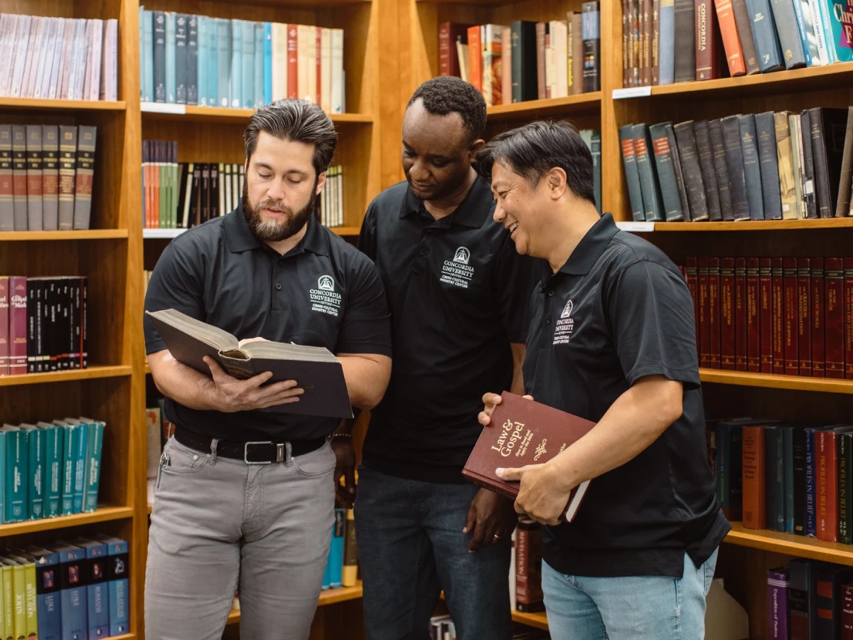 A group of men standing in a library