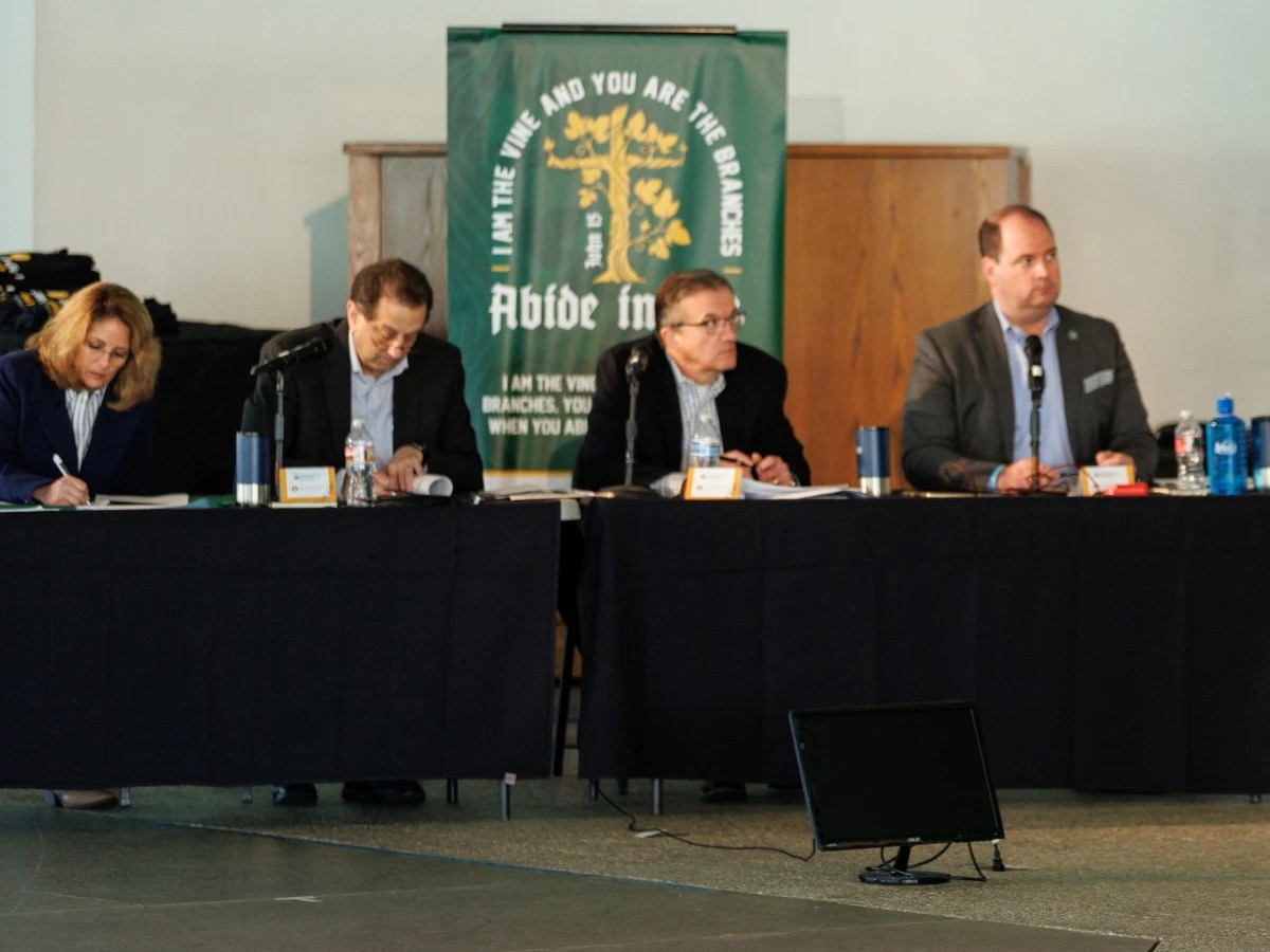 A group of men sitting at a table with microphones