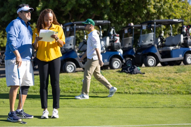 A woman looking at a golf club