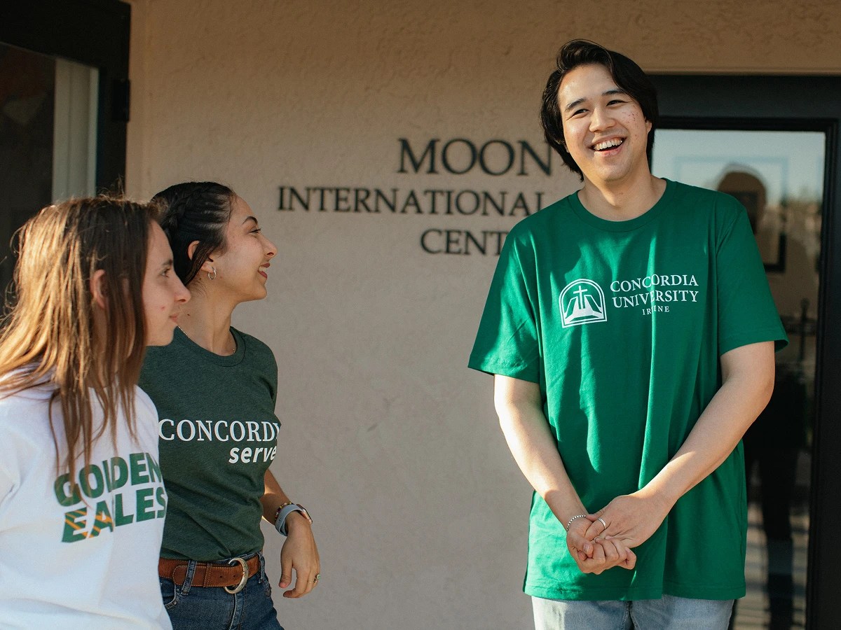 A man in a green shirt standing next to a group of women