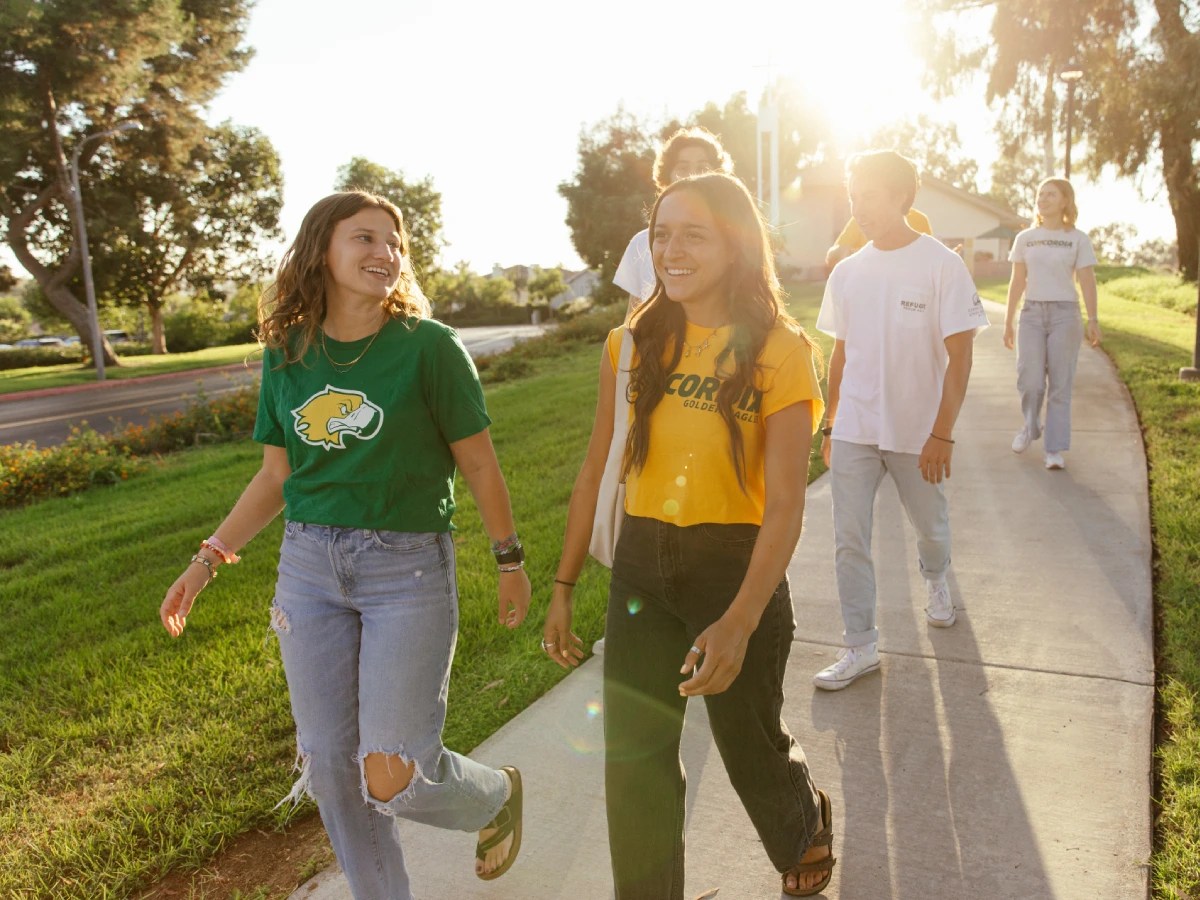 A group of people walking on a sidewalk