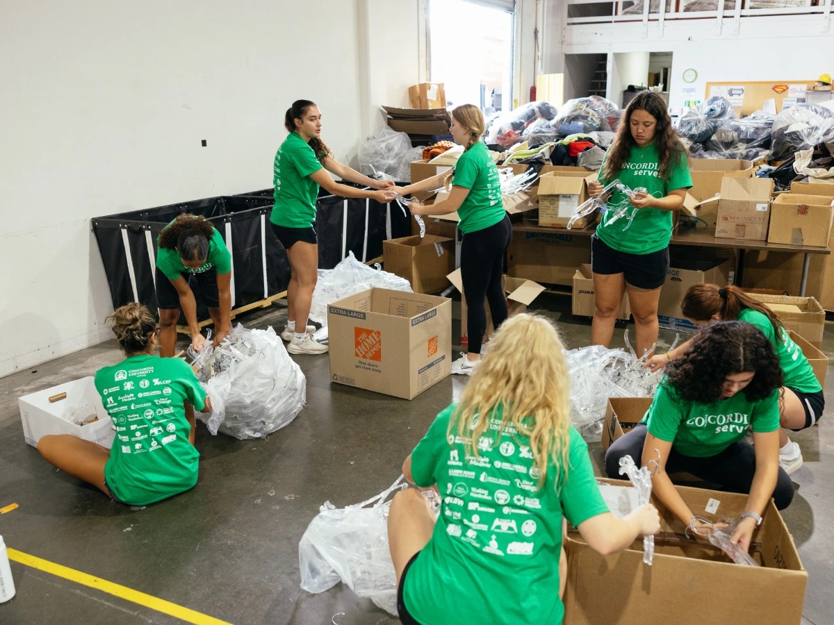 A group of women in green shirts packing plastic