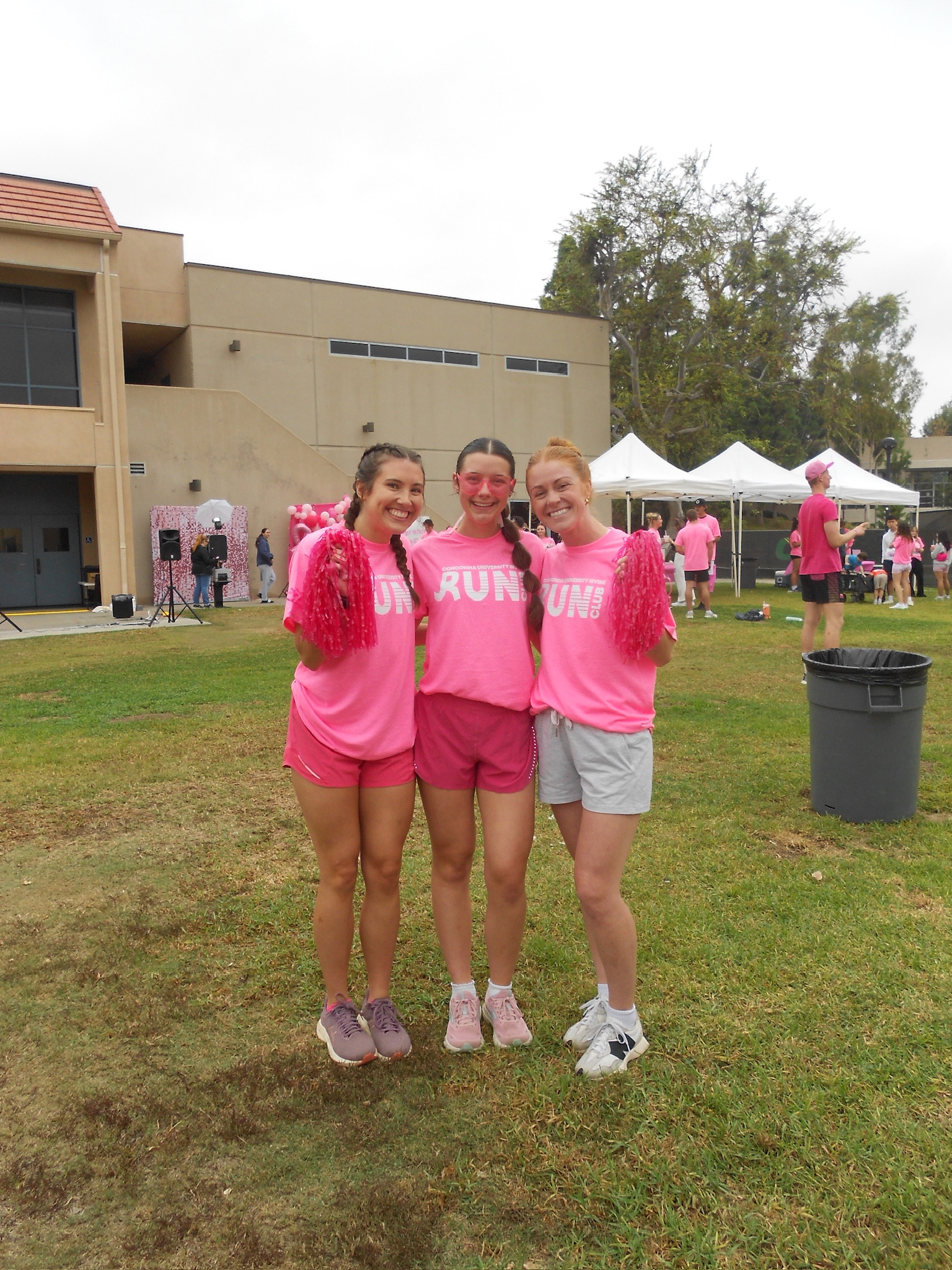 A group of girls wearing pink shirts and pom poms