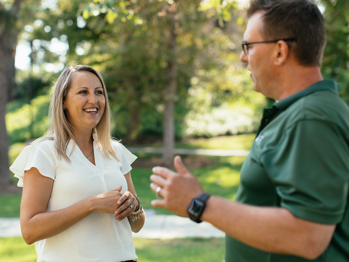 A man and woman talking in a park