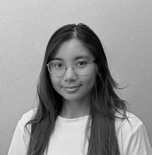 A woman wearing glasses and smiling