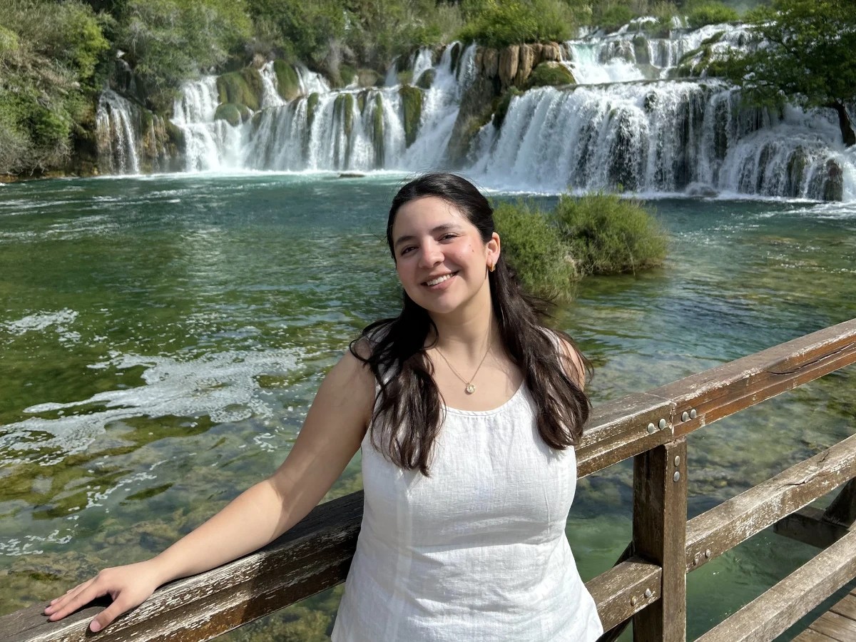 A woman standing in front of a waterfall