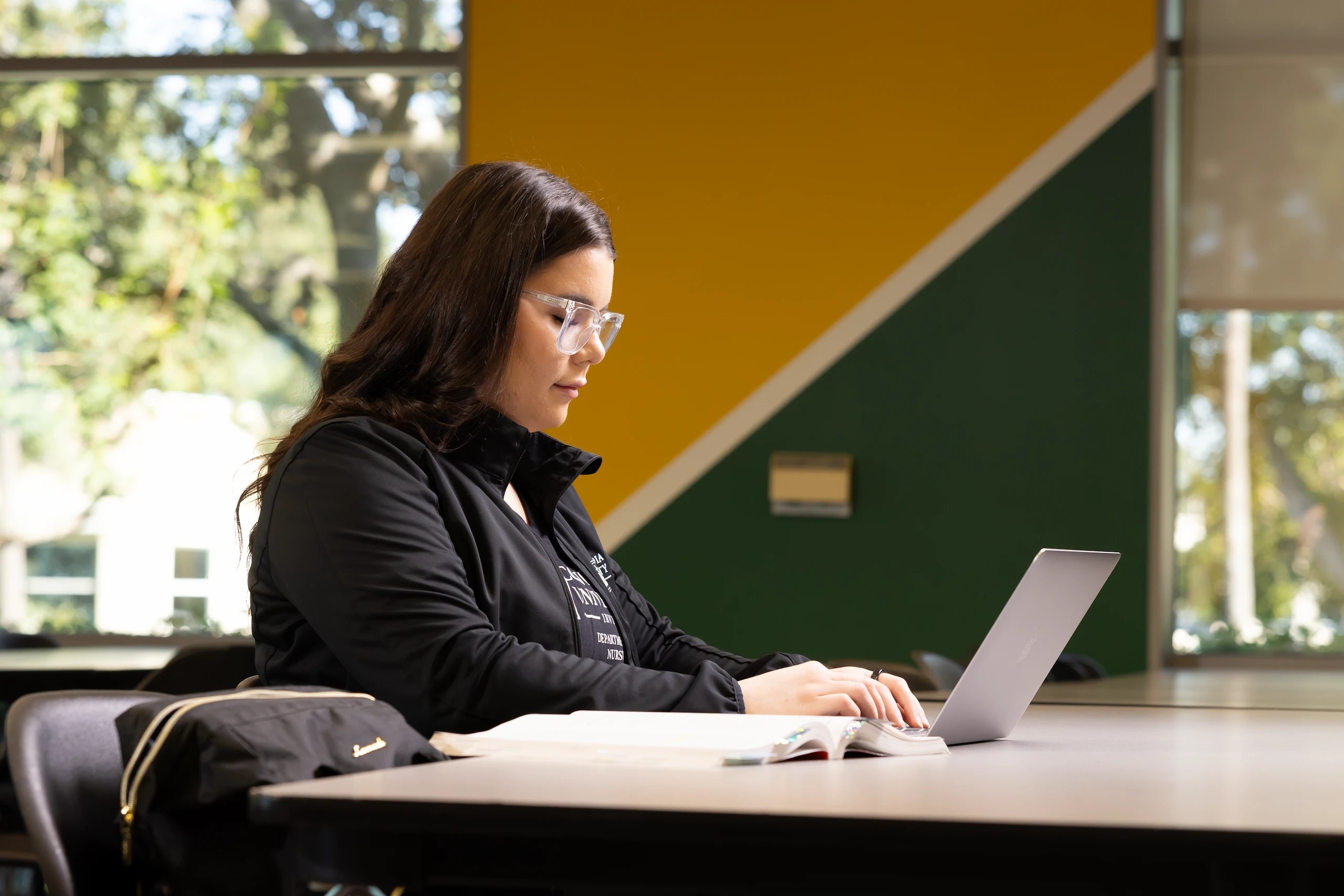 A woman sitting at a table using a laptop