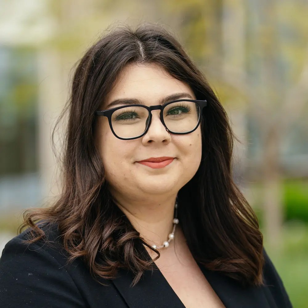 A woman wearing glasses and a black jacket