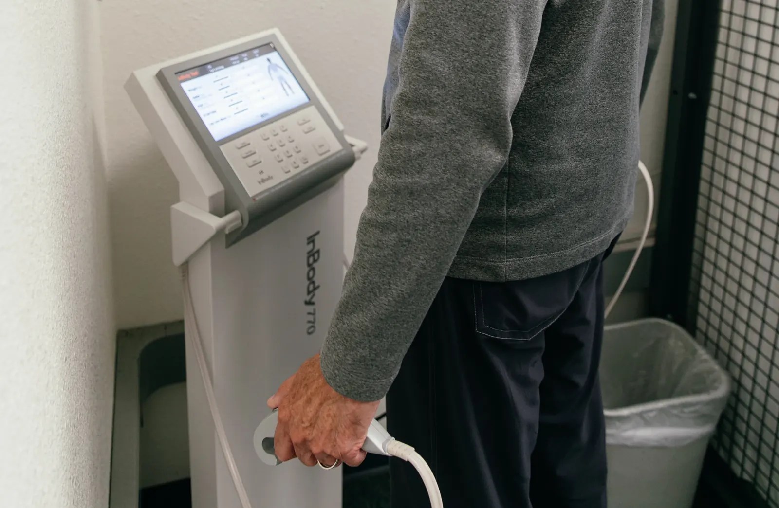 A participant holds the handles of a body composition analyzer.