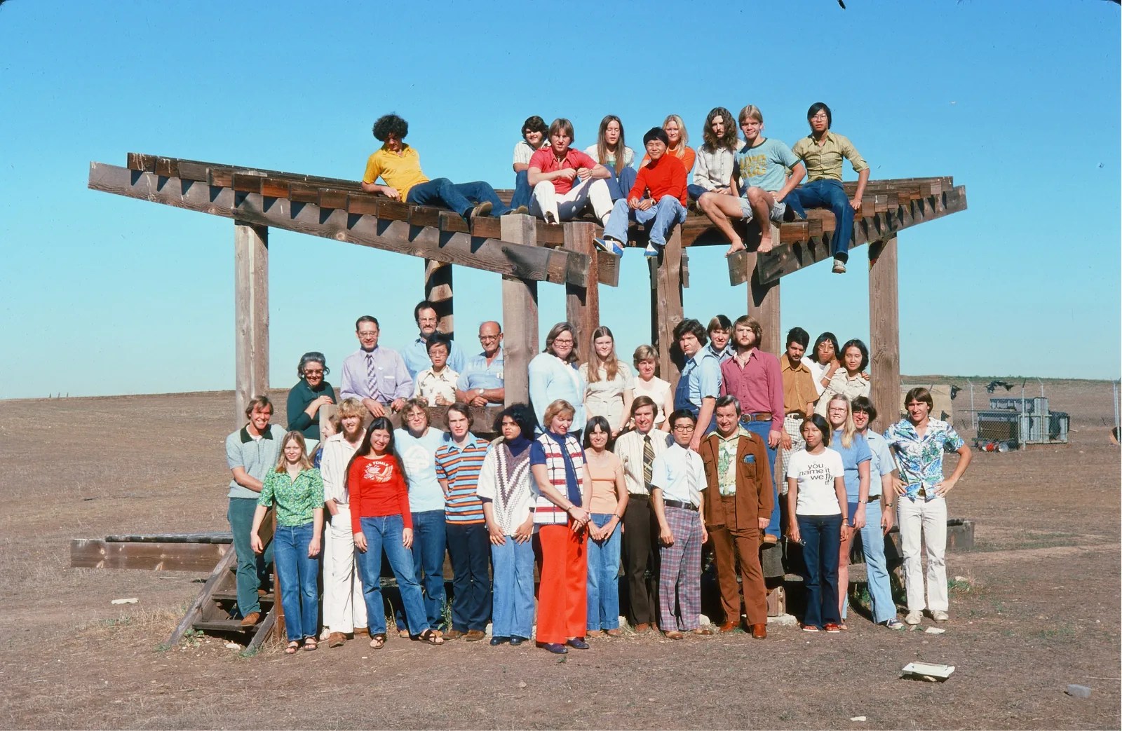 A large group posing on top of and in front of the Bird Sanctuary.