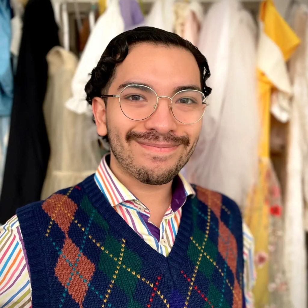 A man wearing glasses and a vest
