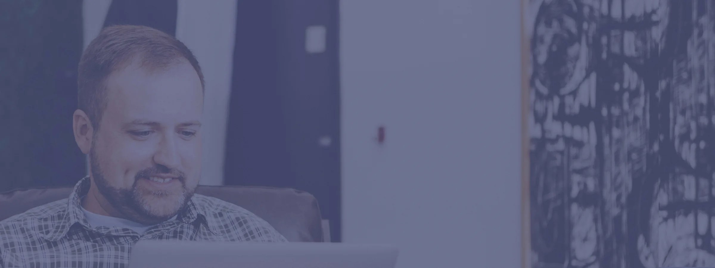 Man reading on a laptop with a blue overlay