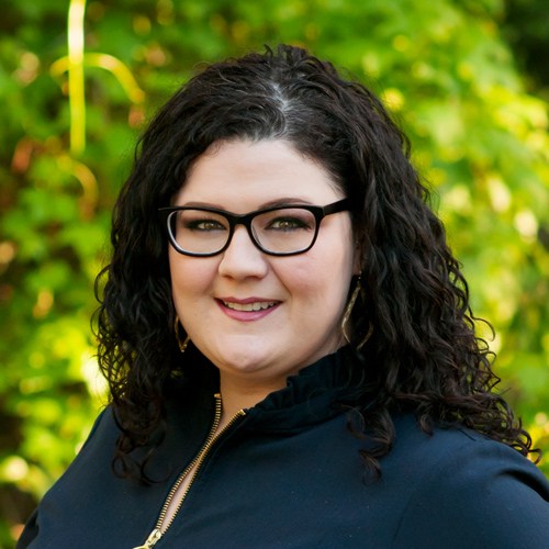 A woman with glasses smiling