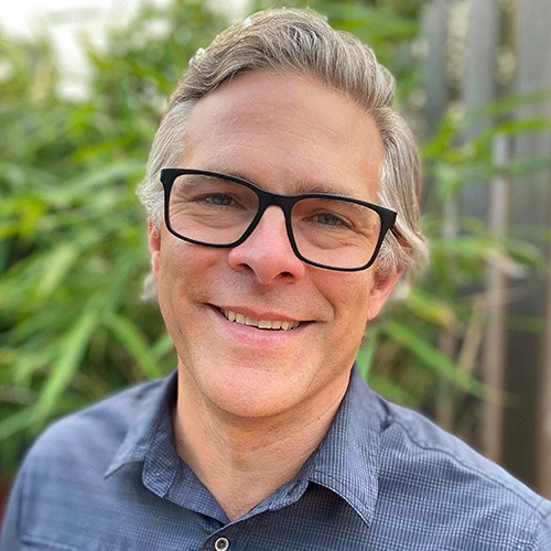 A man wearing glasses smiling
