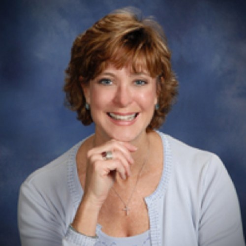 A woman smiling with her hand on her chin