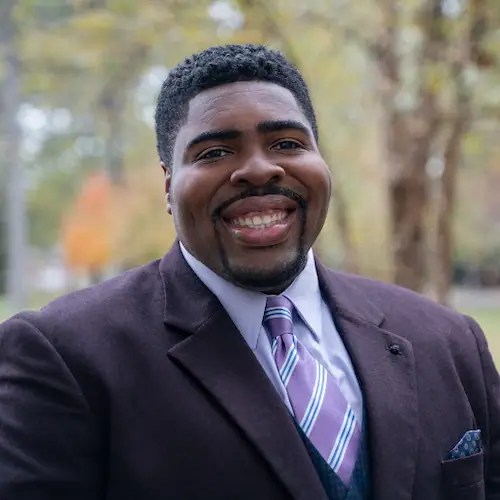 A man in a suit smiling