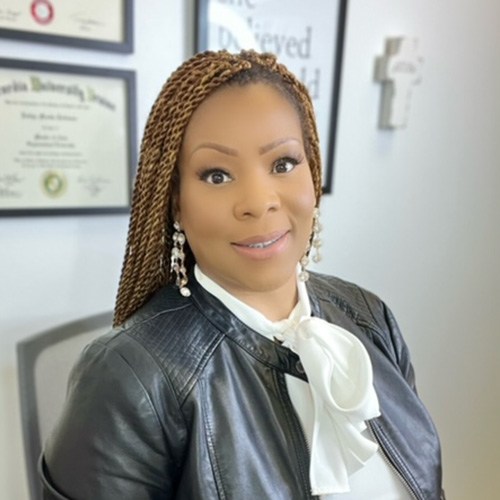 A woman with braids and a black leather jacket